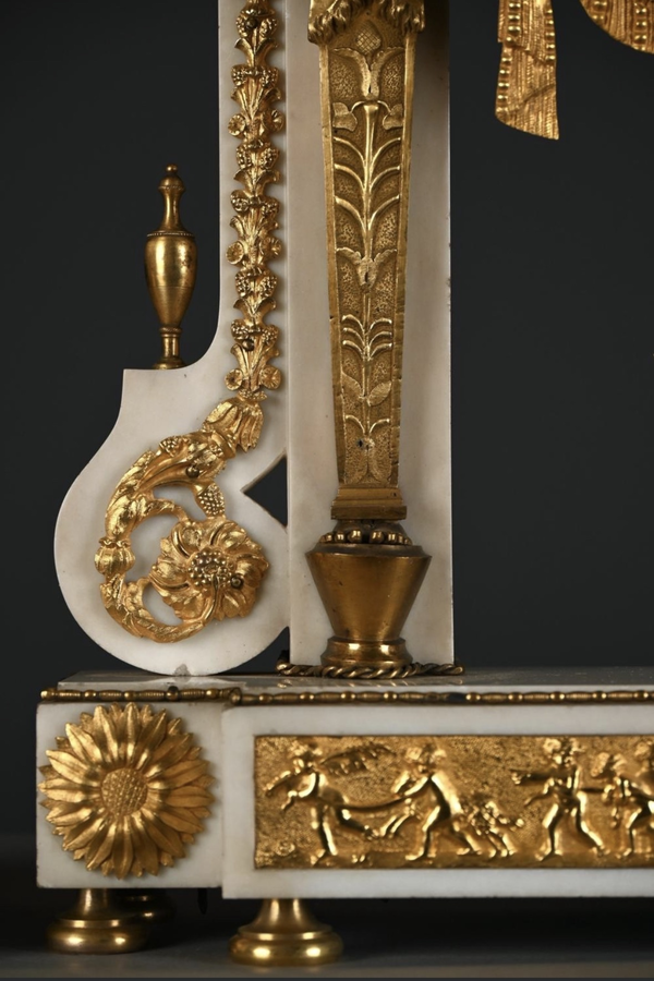 Large Empire-style portico clock (64.5 cm), 19thC. Large clock featuring two marble columns adorned with two caryatids, rosettes, drapery, decorative motifs, two patinated and gilded sphinxes, and an eagle at the top. Sun dial and key included
