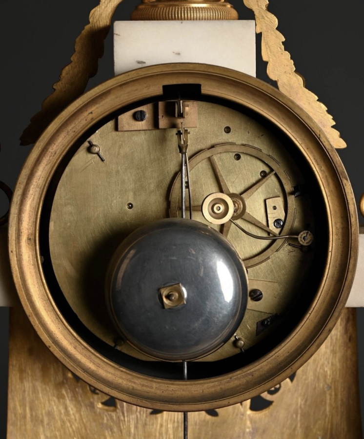Large Empire-style portico clock (64.5 cm), 19thC. Large clock featuring two marble columns adorned with two caryatids, rosettes, drapery, decorative motifs, two patinated and gilded sphinxes, and an eagle at the top. Sun dial and key included