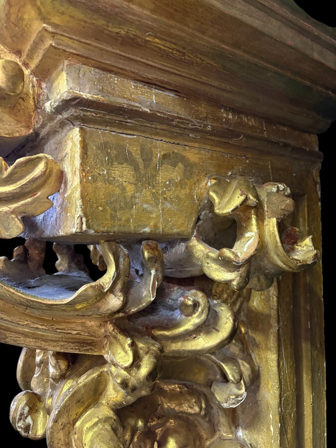 Pair of 17th-century Italian Baroque consoles. Decorative consoles carved in wood, gilded/polychrome, with garlands, fruit, angel heads and decorative ornaments. Ideal for creating a beautiful wall console. Both are in good condition, with normal signs of