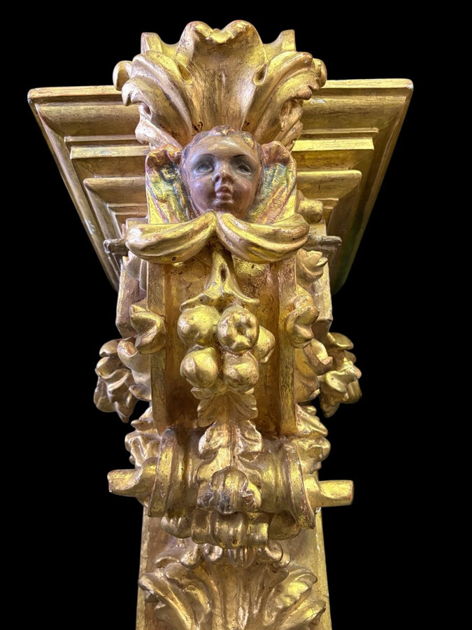 Pair of 17th-century Italian Baroque consoles. Decorative consoles carved in wood, gilded/polychrome, with garlands, fruit, angel heads and decorative ornaments. Ideal for creating a beautiful wall console. Both are in good condition, with normal signs of