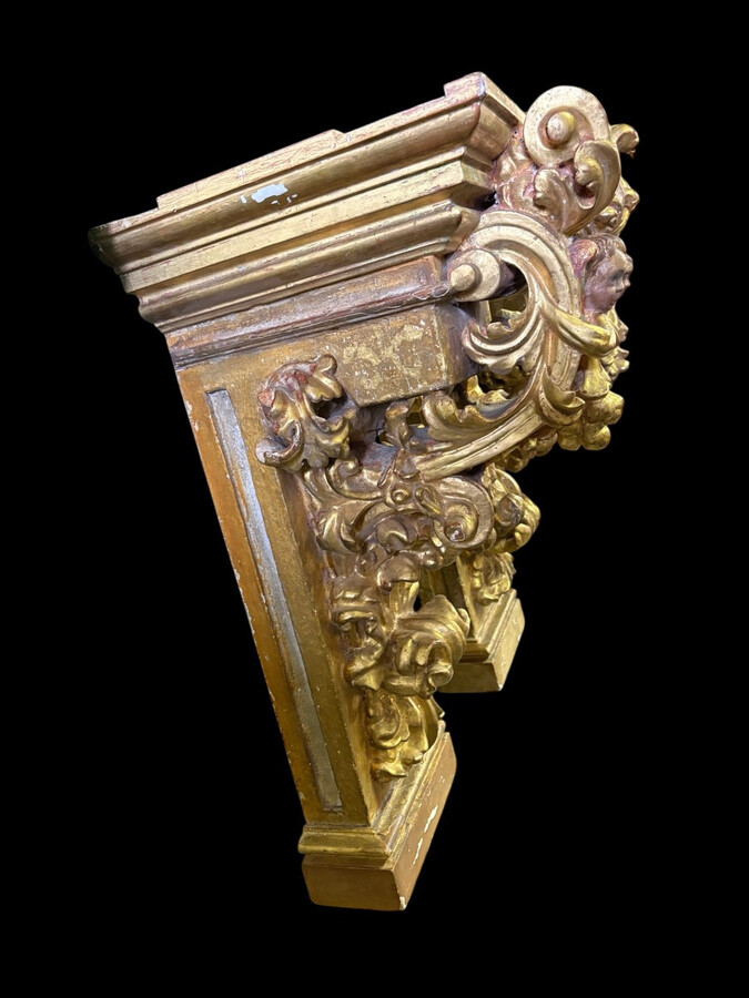 Pair of 17th-century Italian Baroque consoles. Decorative consoles carved in wood, gilded/polychrome, with garlands, fruit, angel heads and decorative ornaments. Ideal for creating a beautiful wall console. Both are in good condition, with normal signs of