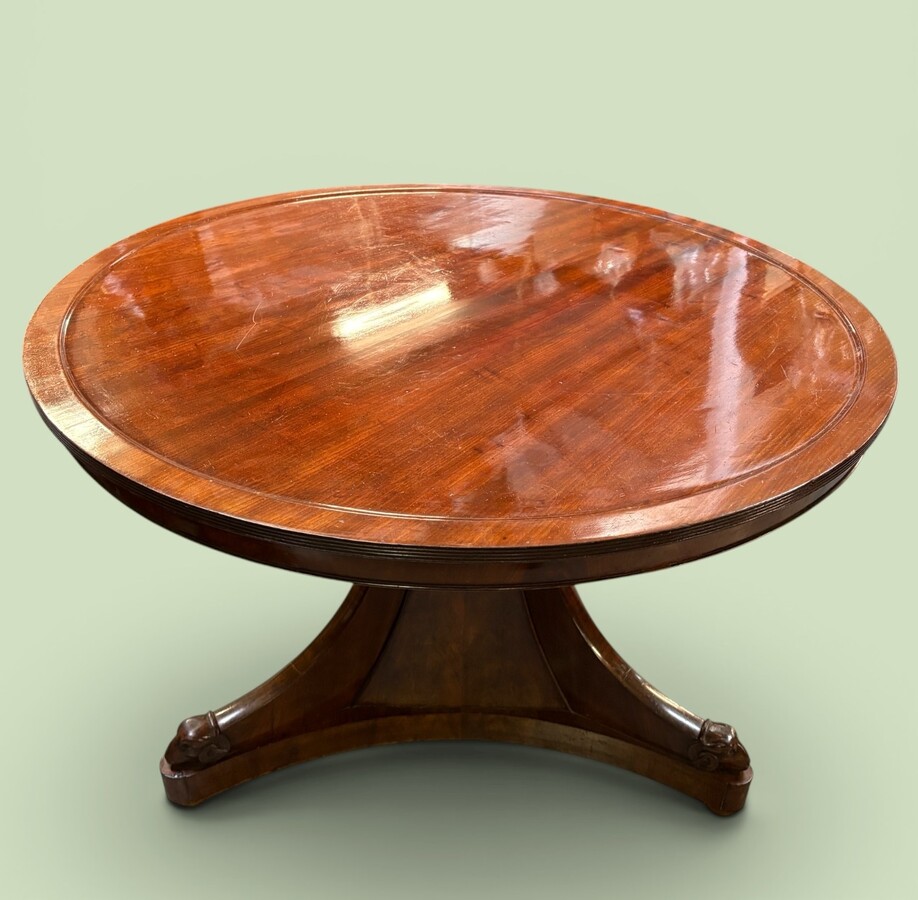 19th-century Charles X-style mahogany pedestal table. Table, featuring three elegant curved legs adorned with ram’s heads. The top is edged with a solid mahogany rim. In good condition, with slight signs of we