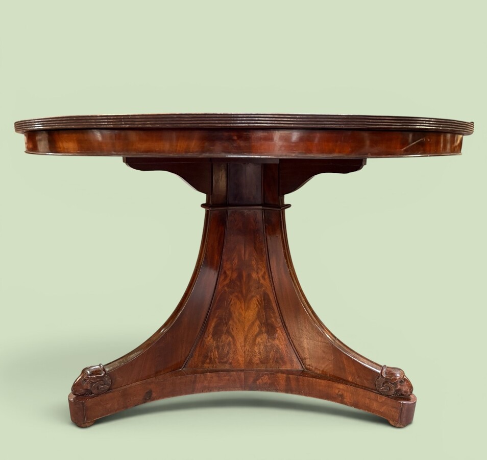  19th-century Charles X-style mahogany pedestal table. Table, featuring three elegant curved legs adorned with ram’s heads. The top is edged with a solid mahogany rim. In good condition, with slight signs of we