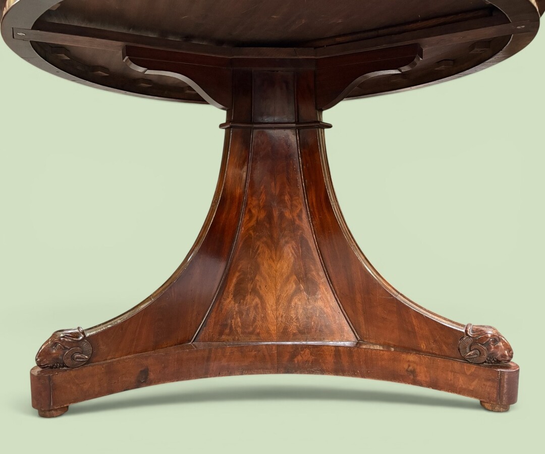  19th-century Charles X-style mahogany pedestal table. Table, featuring three elegant curved legs adorned with ram’s heads. The top is edged with a solid mahogany rim. In good condition, with slight signs of we