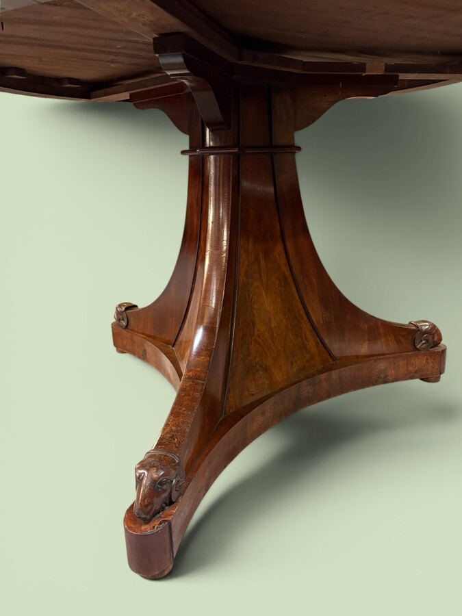  19th-century Charles X-style mahogany pedestal table. Table, featuring three elegant curved legs adorned with ram’s heads. The top is edged with a solid mahogany rim. In good condition, with slight signs of we