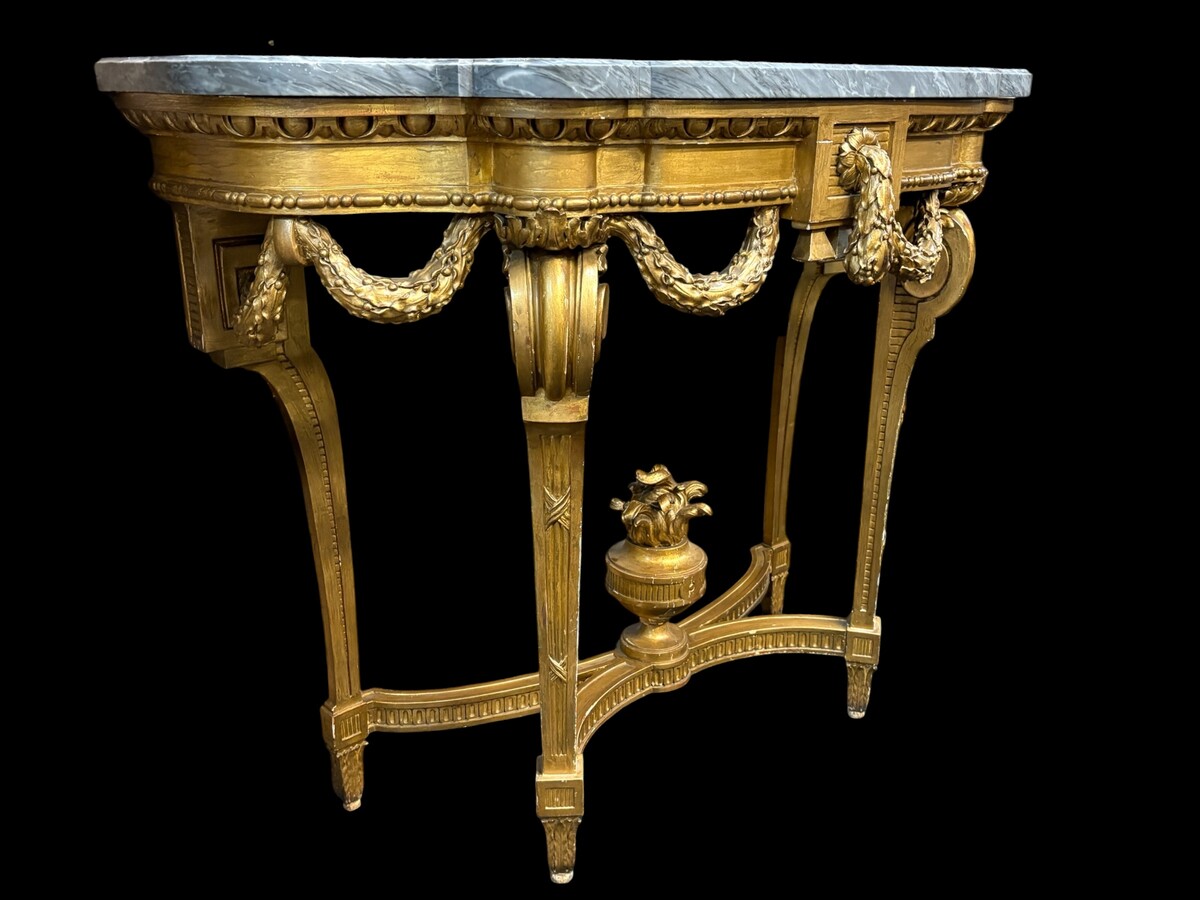  19th-century Louis XVI-style console table in gilded wood. The console features four legs decorated with garlands and a large vase at the base, topped with a superb 3 cm thick grey marble top. The console and marble top are in good condition, w