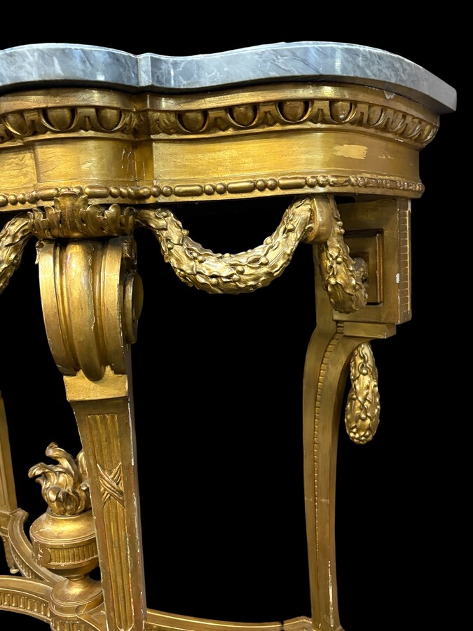  19th-century Louis XVI-style console table in gilded wood. The console features four legs decorated with garlands and a large vase at the base, topped with a superb 3 cm thick grey marble top. The console and marble top are in good condition, w
