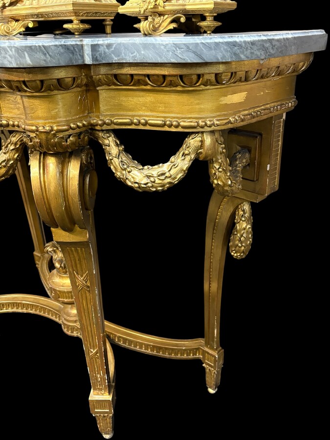  19th-century Louis XVI-style console table in gilded wood. The console features four legs decorated with garlands and a large vase at the base, topped with a superb 3 cm thick grey marble top. The console and marble top are in good condition, w