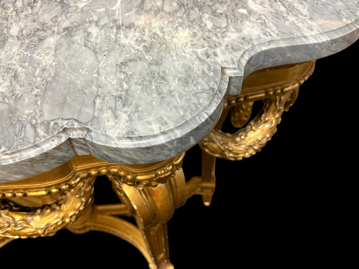  19th-century Louis XVI-style console table in gilded wood. The console features four legs decorated with garlands and a large vase at the base, topped with a superb 3 cm thick grey marble top. The console and marble top are in good condition, w
