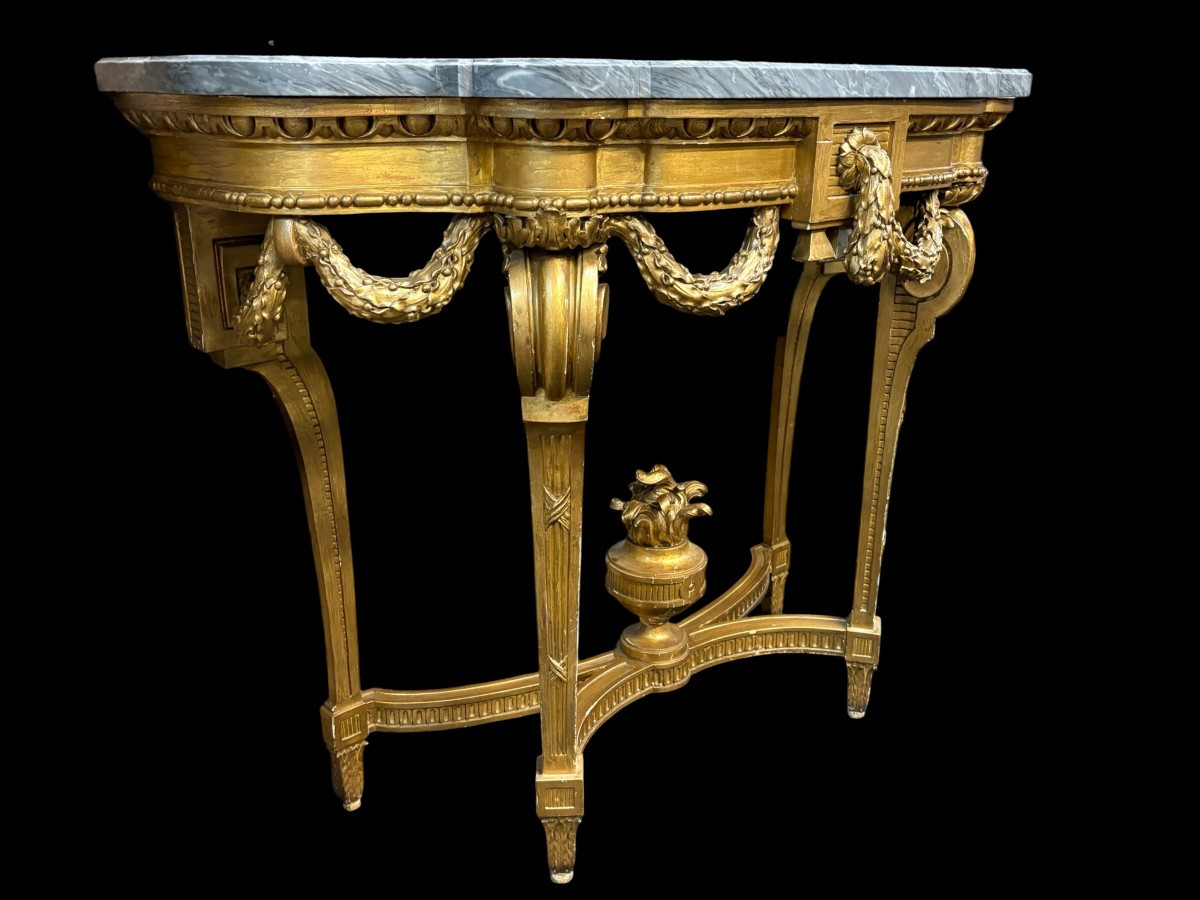 19th-century Louis XVI-style console table in gilded wood. The console features four legs decorated with garlands and a large vase at the base, topped with a superb 3 cm thick grey marble top. The console and marble top are in good condition