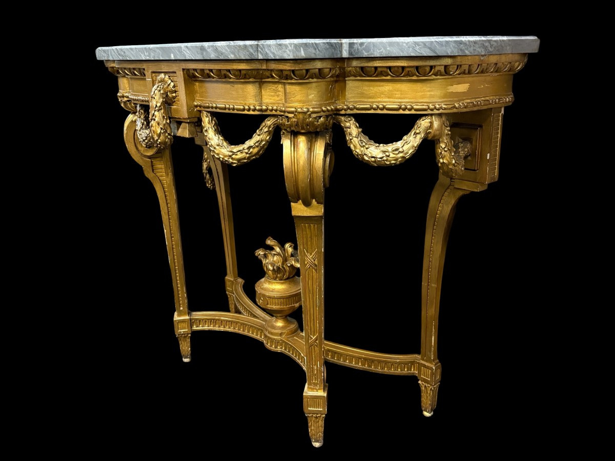 19th-century Louis XVI-style console table in gilded wood. The console features four legs decorated with garlands and a large vase at the base, topped with a superb 3 cm thick grey marble top. The console and marble top are in good condition