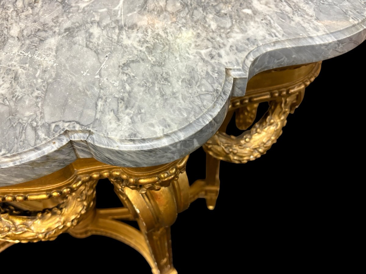 19th-century Louis XVI-style console table in gilded wood. The console features four legs decorated with garlands and a large vase at the base, topped with a superb 3 cm thick grey marble top. The console and marble top are in good condition