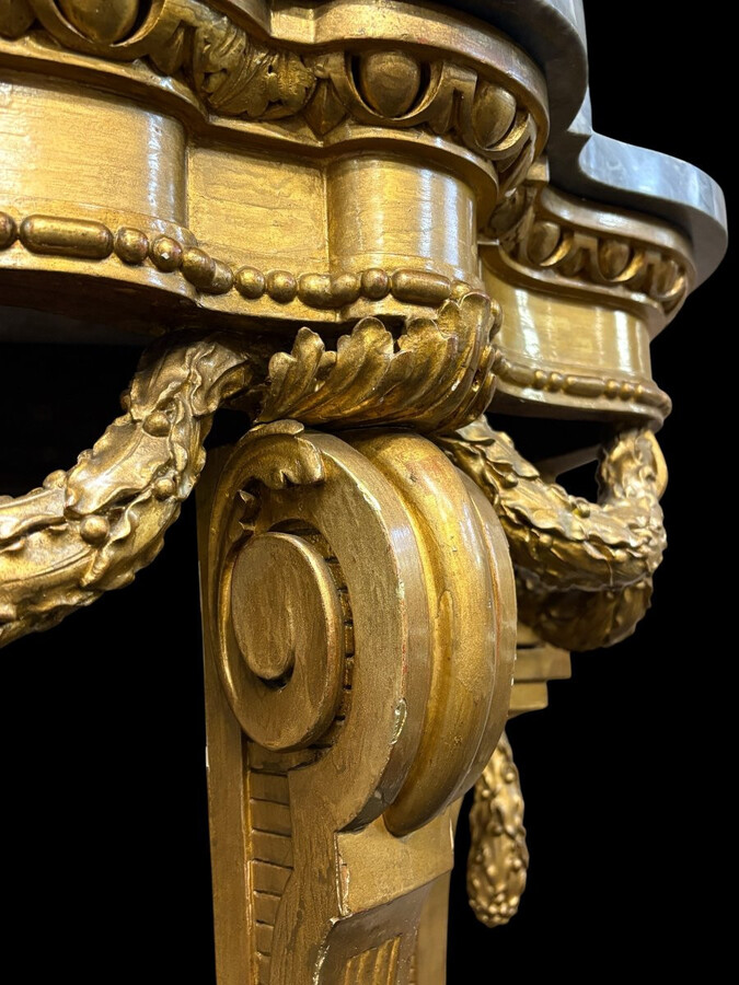 19th-century Louis XVI-style console table in gilded wood. The console features four legs decorated with garlands and a large vase at the base, topped with a superb 3 cm thick grey marble top. The console and marble top are in good condition