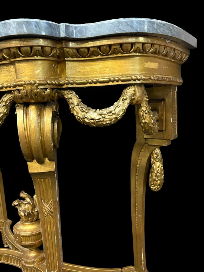 19th-century Louis XVI-style console table in gilded wood. The console features four legs decorated with garlands and a large vase at the base, topped with a superb 3 cm thick grey marble top. The console and marble top are in good condition