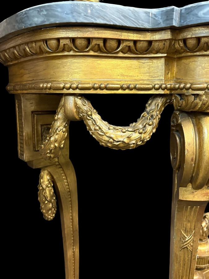 19th-century Louis XVI-style console table in gilded wood. The console features four legs decorated with garlands and a large vase at the base, topped with a superb 3 cm thick grey marble top. The console and marble top are in good condition