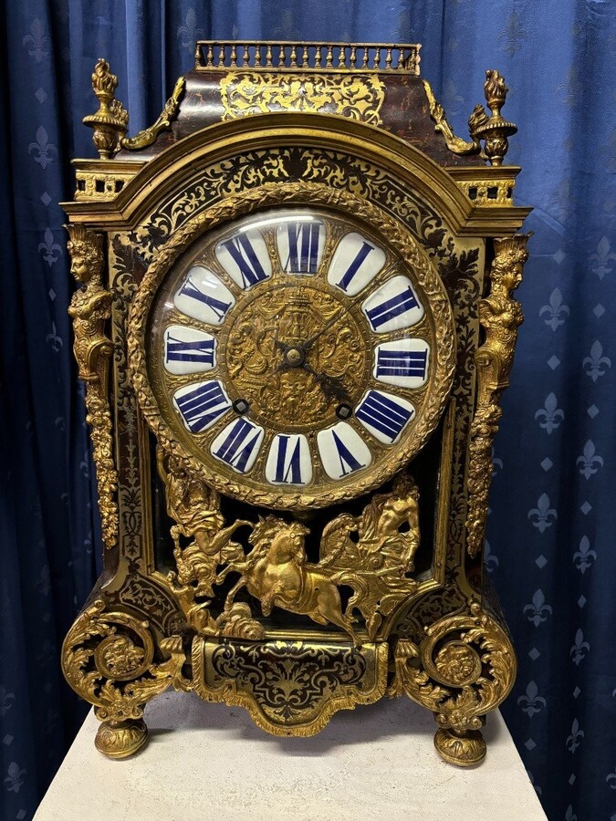 A large brass inlaid cartel on a tortoiseshell background, 18th century, Régence period. Rectangular cartel ending in scrolls decorated with gilt bronze on the front and a tripod in the centre. Gilt bronze dial with enamelled cartouches