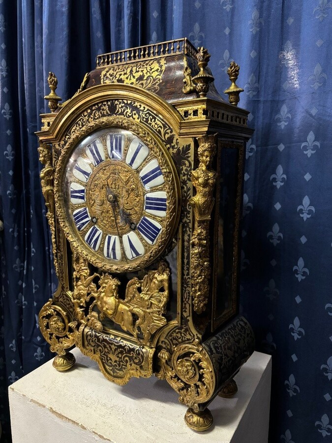 A large brass inlaid cartel on a tortoiseshell background, 18th century, Régence period. Rectangular cartel ending in scrolls decorated with gilt bronze on the front and a tripod in the centre. Gilt bronze dial with enamelled cartouches