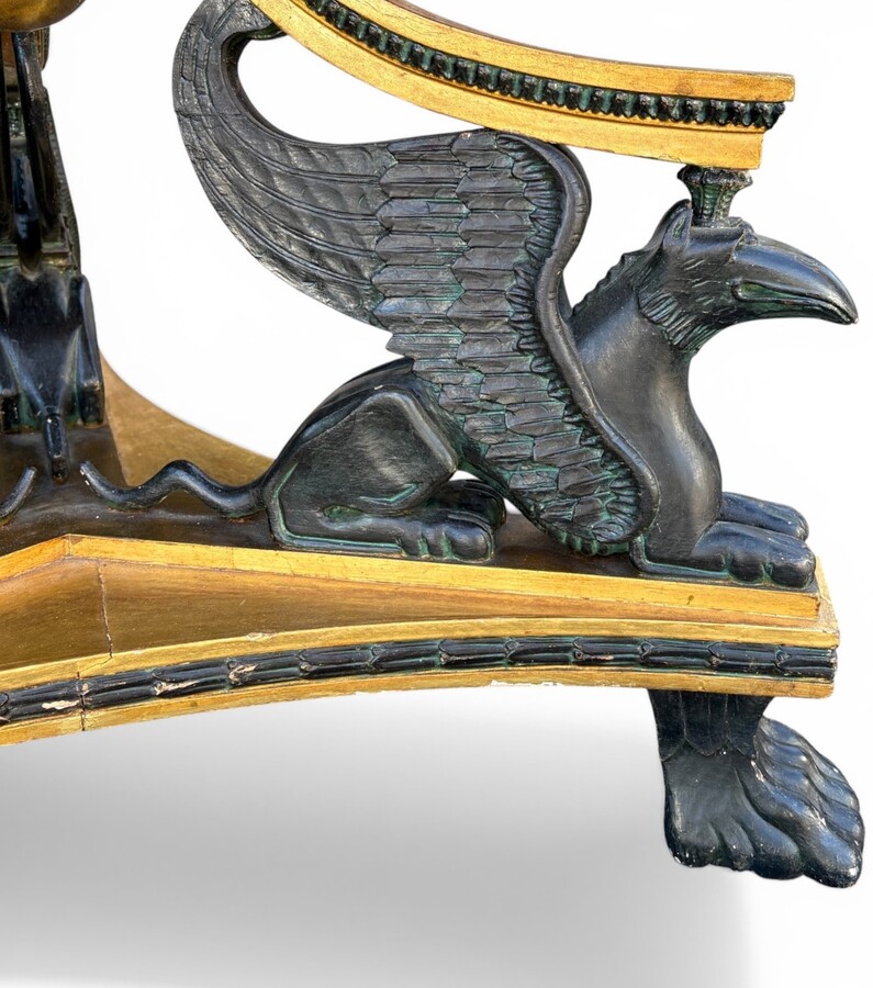 A lovely Empire-style center table, 1830–1840 A highly decorative center table in patinated and gilded wood, comprising a three-legged base adorned with three reclining winged mythological creatures and a suspended gilded wooden sphere