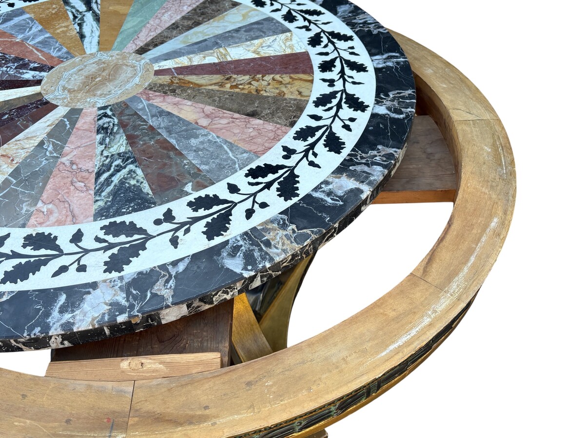 A lovely Empire-style center table, 1830–1840 A highly decorative center table in patinated and gilded wood, comprising a three-legged base adorned with three reclining winged mythological creatures and a suspended gilded wooden sphere