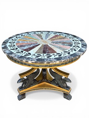A lovely Empire-style center table, 1830–1840 A highly decorative center table in patinated and gilded wood, comprising a three-legged base adorned with three reclining winged mythological creatures and a suspended gilded wooden sphere