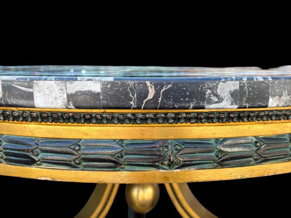 A lovely Empire-style center table, 1830–1840 A highly decorative center table in patinated and gilded wood, comprising a three-legged base adorned with three reclining winged mythological creatures and a suspended gilded wooden sphere