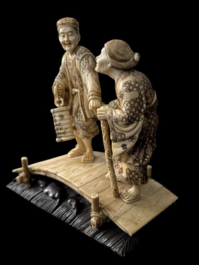 A nice ivory sculpture, China, 19th century An ivory sculpture with very fine detail depicting an elderly couple in kimonos walking across a bridge over water The water beneath the bridge is carved from wood. Dimensions: Width: 17 cm Height: 18 cm