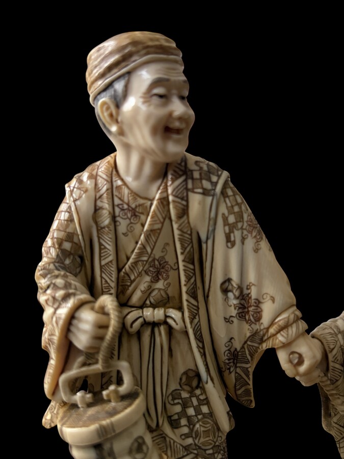 A nice ivory sculpture, China, 19th century An ivory sculpture with very fine detail depicting an elderly couple in kimonos walking across a bridge over water The water beneath the bridge is carved from wood. Dimensions: Width: 17 cm Height: 18 cm