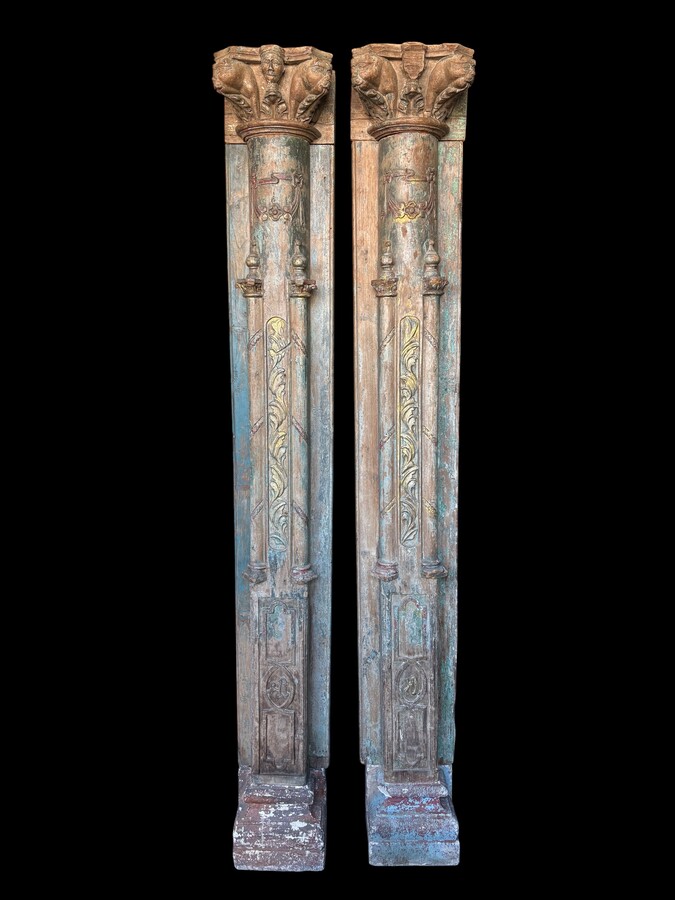 A pair of large decorative wooden columns with 19th-century capitals.Nice columns showing traces of their former polychrome finish, comprising three parts: a carved wooden capital, a decorated column and a stone plinth. In normal condition.