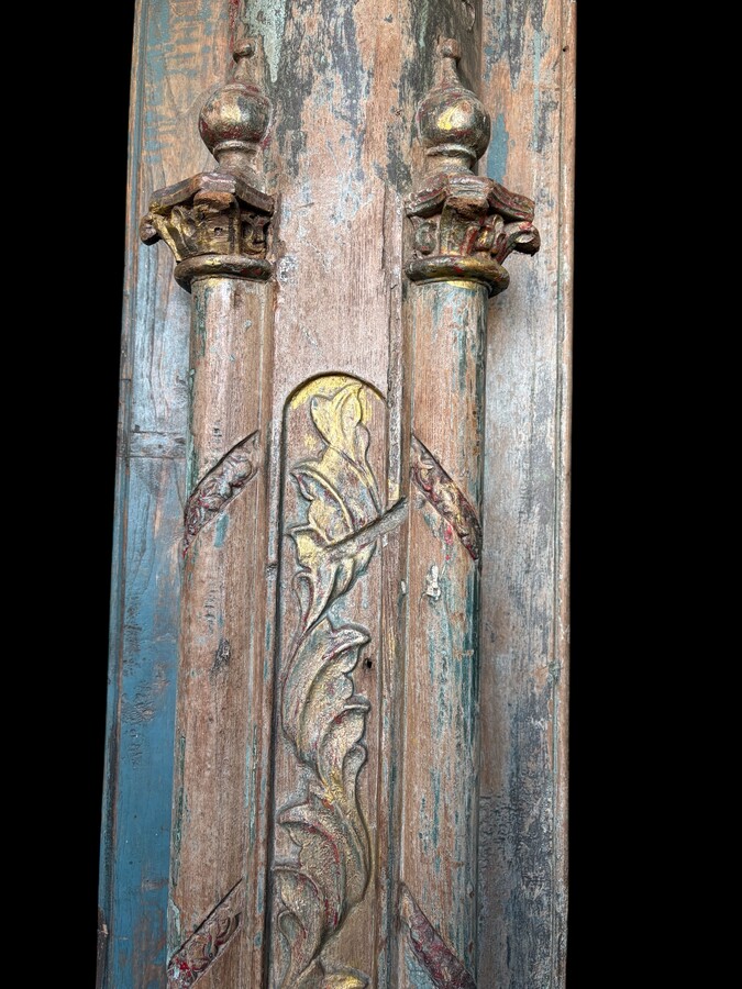 A pair of large decorative wooden columns with 19th-century capitals.Nice columns showing traces of their former polychrome finish, comprising three parts: a carved wooden capital, a decorated column and a stone plinth. In normal condition.