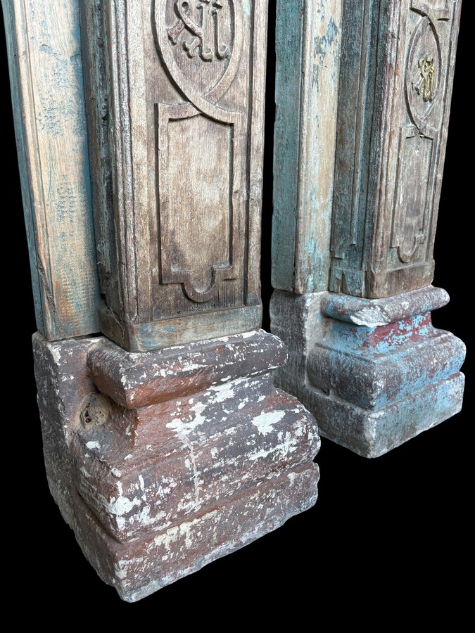 A pair of large decorative wooden columns with 19th-century capitals.Nice columns showing traces of their former polychrome finish, comprising three parts: a carved wooden capital, a decorated column and a stone plinth. In normal condition.