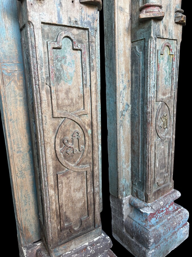 A pair of large decorative wooden columns with 19th-century capitals.Nice columns showing traces of their former polychrome finish, comprising three parts: a carved wooden capital, a decorated column and a stone plinth. In normal condition.