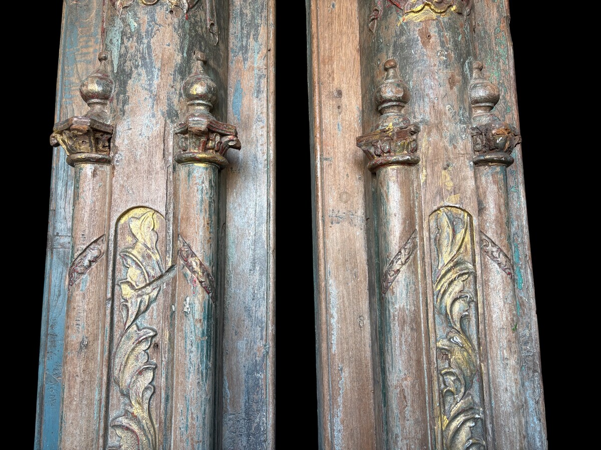 A pair of large decorative wooden columns with 19th-century capitals.Nice columns showing traces of their former polychrome finish, comprising three parts: a carved wooden capital, a decorated column and a stone plinth. In normal condition.