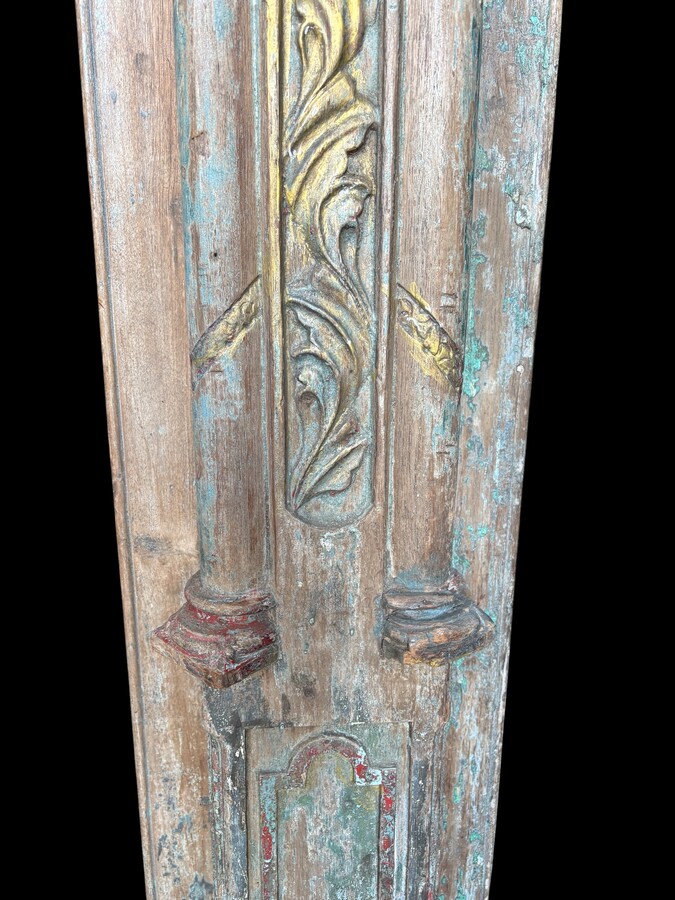A pair of large decorative wooden columns with 19th-century capitals.Nice columns showing traces of their former polychrome finish, comprising three parts: a carved wooden capital, a decorated column and a stone plinth. In normal condition.