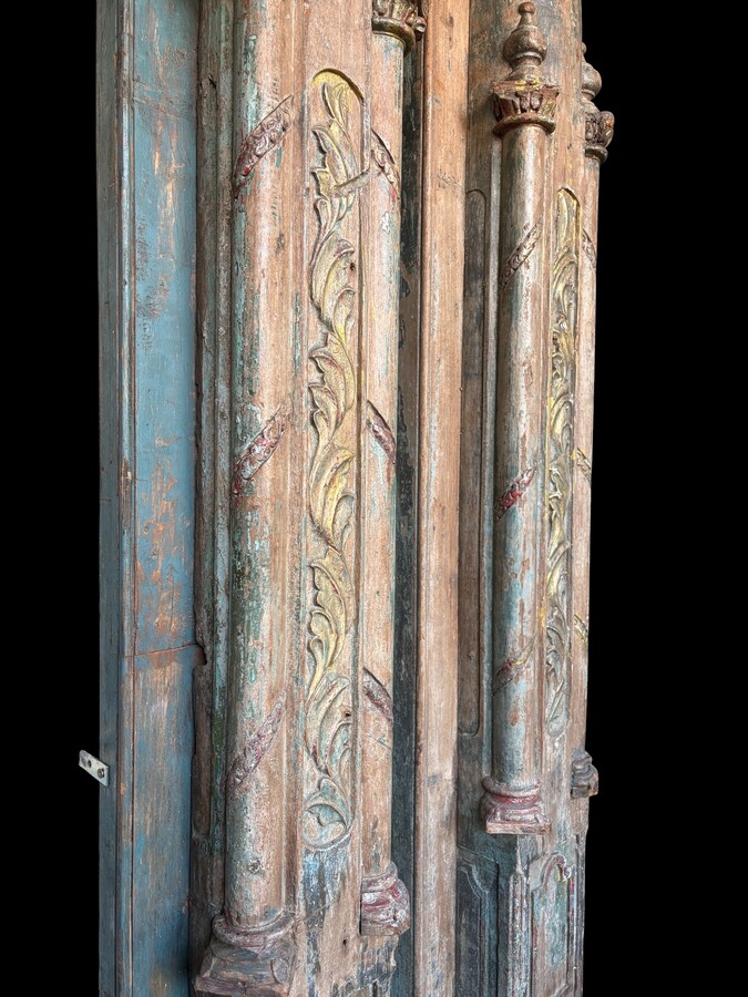 A pair of large decorative wooden columns with 19th-century capitals.Nice columns showing traces of their former polychrome finish, comprising three parts: a carved wooden capital, a decorated column and a stone plinth. In normal condition.
