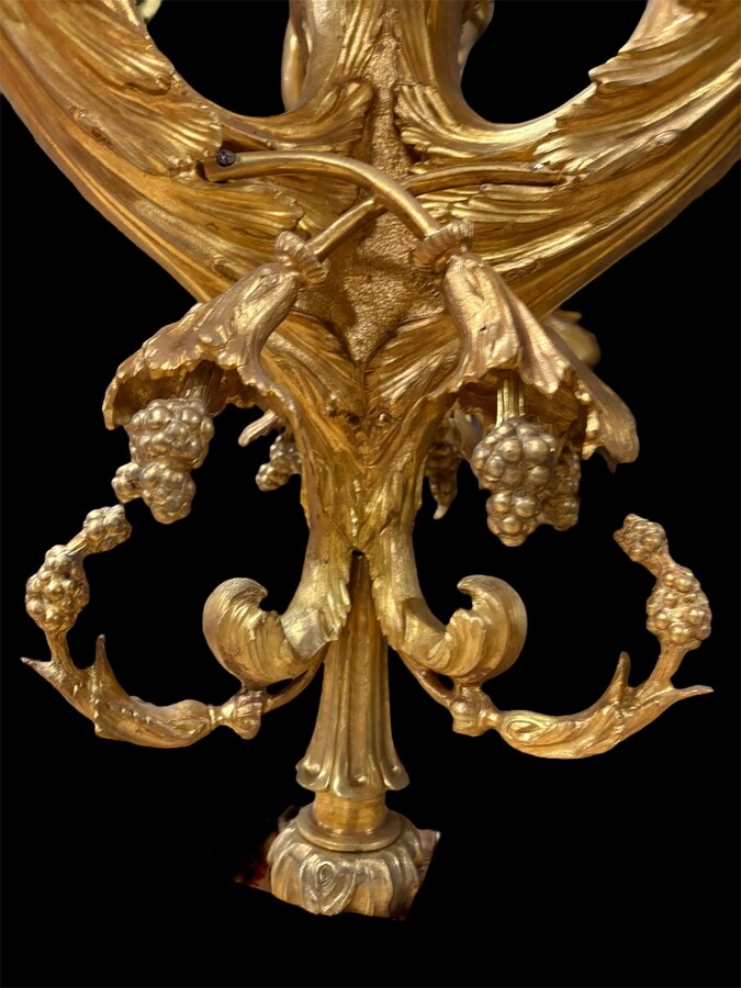 A pair of large gilded bronze chandeliers depicting three mythological women , 20thC. Nice chandeliers with 15 light points, featuring three mythological women holding a bouquet of flowers; at the top, a large Louis XVI-style bow 