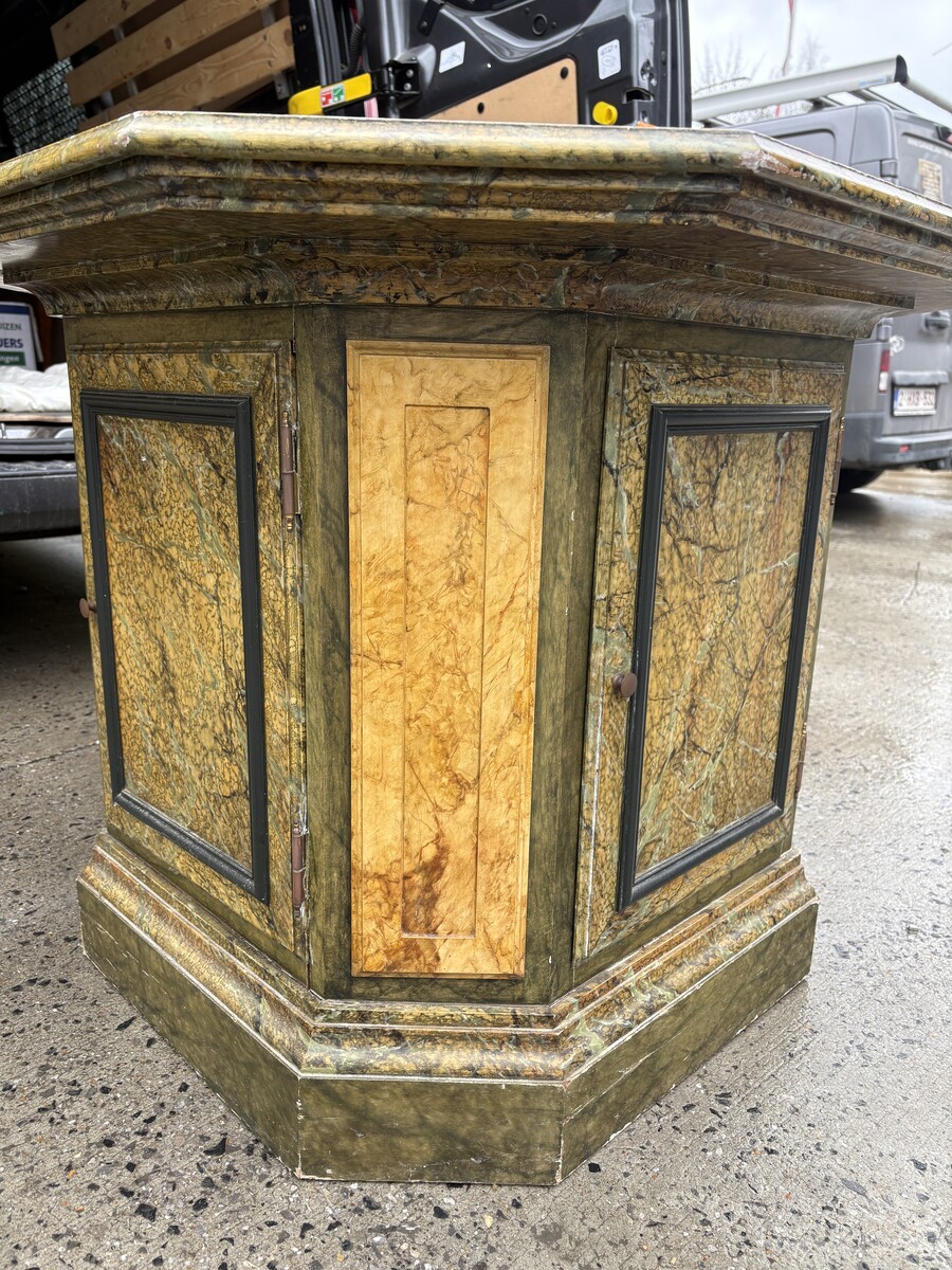 A special table painted to resemble marble 20th century. A decorative piece that can be used as a table, a pedestal or a piece of furniture. It features a triangular wooden top resting on a wooden base fitted with four panelled doors