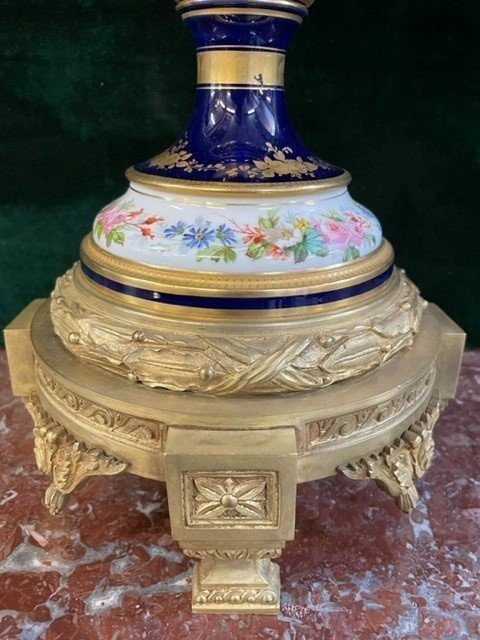 A Very Large Napoleon III Period Vase In Sevres Porcelain Decorated With A Gallant Scene On One Side And A Landscape On The Other Side, Gilded With Gold, Floral Motif And Oven Blue Background. Chased Bronze And Gilt Bronze Mount