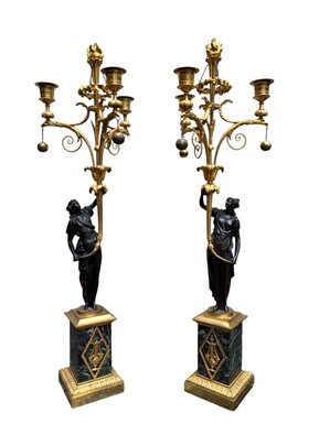 An elegant pair of candelabras in finely chased, gilded and patinated bronze. The shaft is adorned with an antique draped female figure, resting on a green marble base. In the Louis XVI style, these pieces date from the early 19th century. 