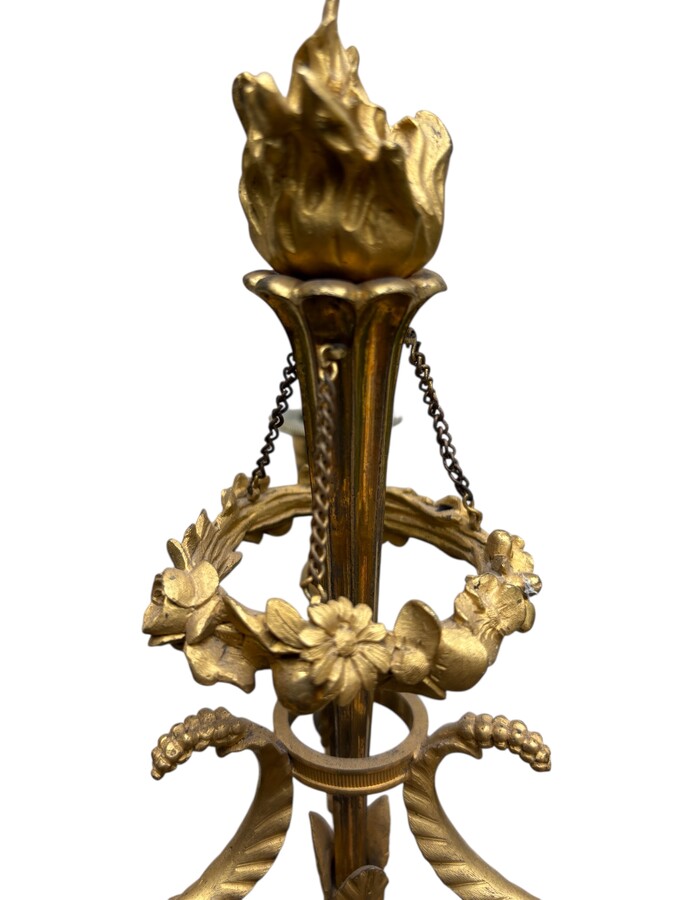 An elegant pair of candelabras in finely chased, gilded and patinated bronze. The shaft is adorned with an antique draped female figure, resting on a green marble base. In the Louis XVI style, these pieces date from the early 19th century. 