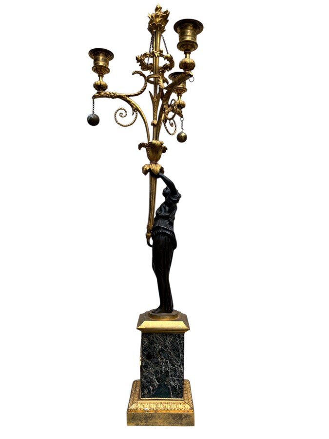 An elegant pair of candelabras in finely chased, gilded and patinated bronze. The shaft is adorned with an antique draped female figure, resting on a green marble base. In the Louis XVI style, these pieces date from the early 19th century. 
