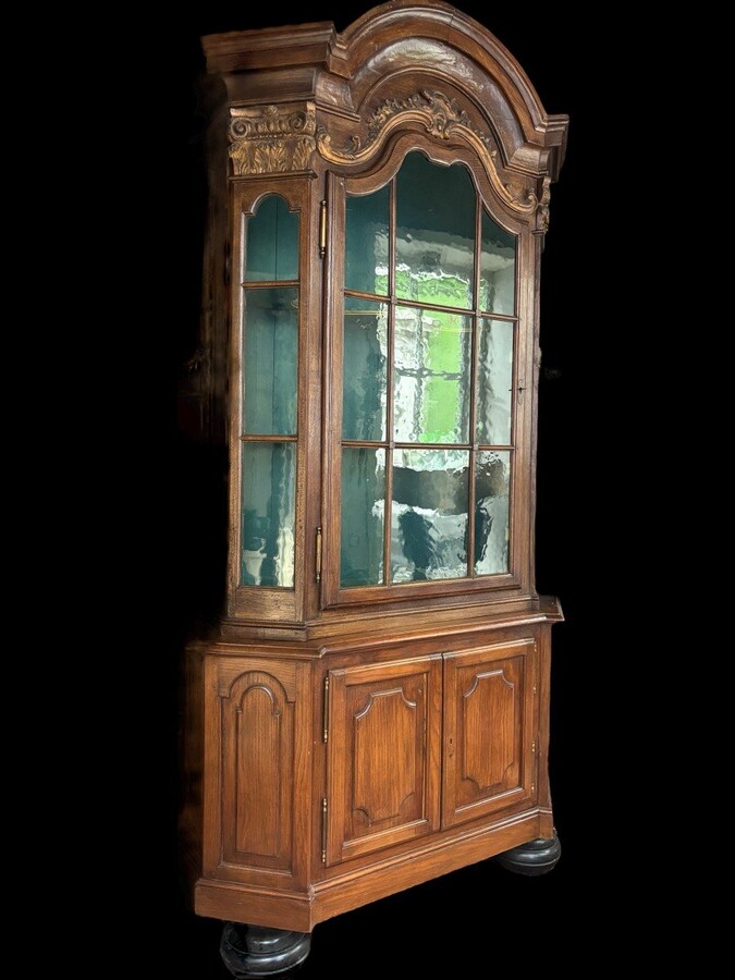 Beautiful 18thC. Castle display cabinet in oak Furniture with chamfered corners , large curved cornice , 1 large display door at the top , 2 paneled doors at the bottom Decorated at the top with wooden gilt decorative elements and capitals.
