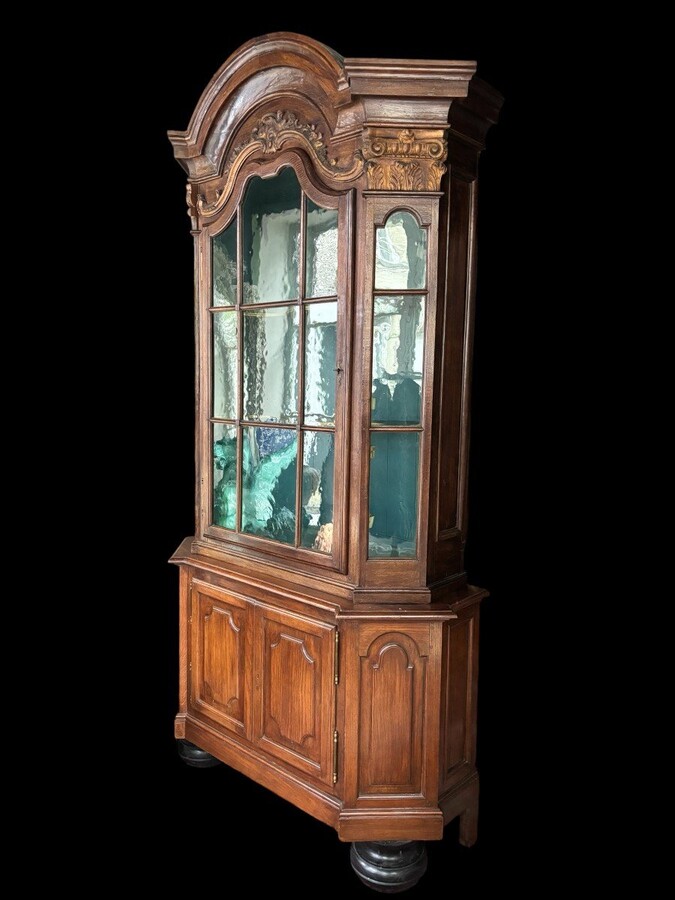 Beautiful 18thC. Castle display cabinet in oak Furniture with chamfered corners , large curved cornice , 1 large display door at the top , 2 paneled doors at the bottom Decorated at the top with wooden gilt decorative elements and capitals.