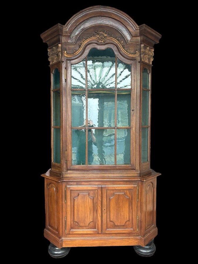 Beautiful 18thC. Castle display cabinet in oak Furniture with chamfered corners , large curved cornice , 1 large display door at the top , 2 paneled doors at the bottom Decorated at the top with wooden gilt decorative elements and capitals.