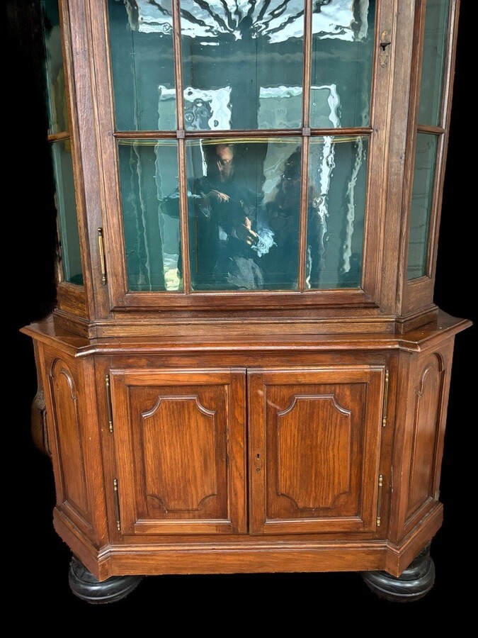 Beautiful 18thC. Castle display cabinet in oak Furniture with chamfered corners , large curved cornice , 1 large display door at the top , 2 paneled doors at the bottom Decorated at the top with wooden gilt decorative elements and capitals.
