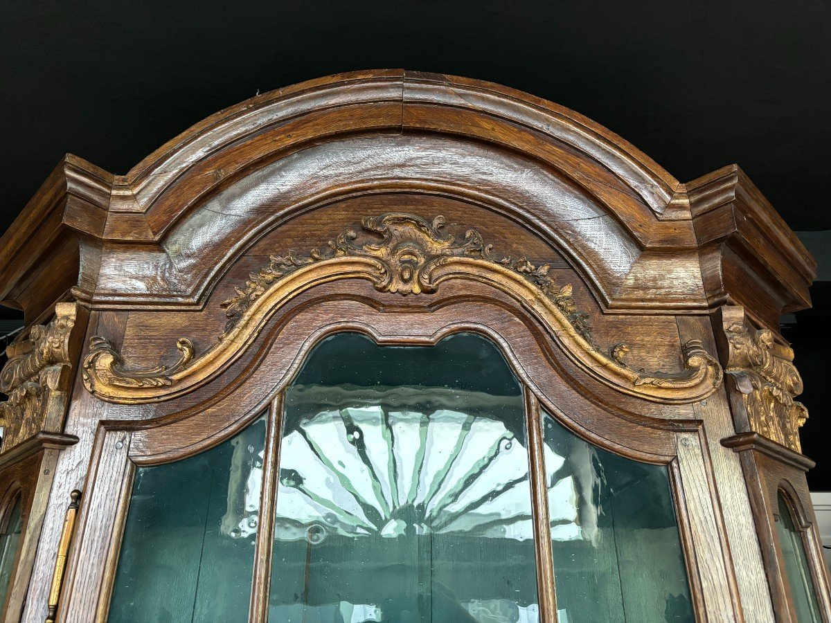 Beautiful 18thC. Castle display cabinet in oak Furniture with chamfered corners , large curved cornice , 1 large display door at the top , 2 paneled doors at the bottom Decorated at the top with wooden gilt decorative elements and capitals.
