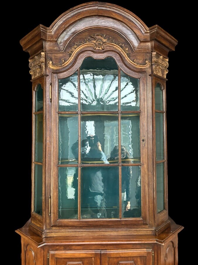 Beautiful 18thC. Castle display cabinet in oak Furniture with chamfered corners , large curved cornice , 1 large display door at the top , 2 paneled doors at the bottom Decorated at the top with wooden gilt decorative elements and capitals.