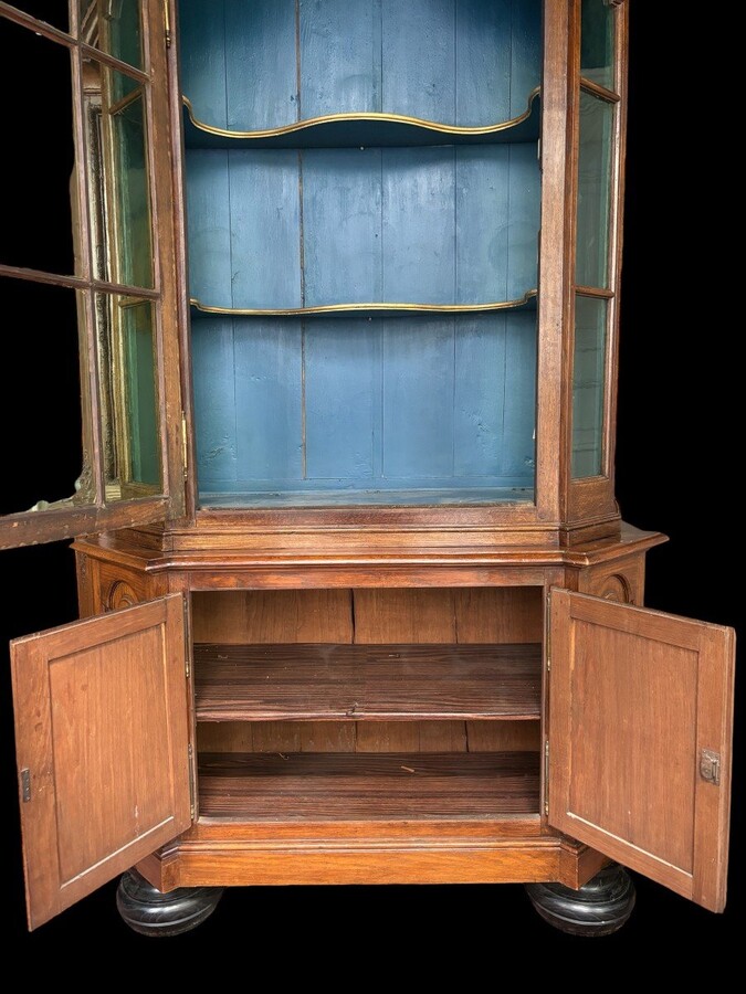 Beautiful 18thC. Castle display cabinet in oak Furniture with chamfered corners , large curved cornice , 1 large display door at the top , 2 paneled doors at the bottom Decorated at the top with wooden gilt decorative elements and capitals.