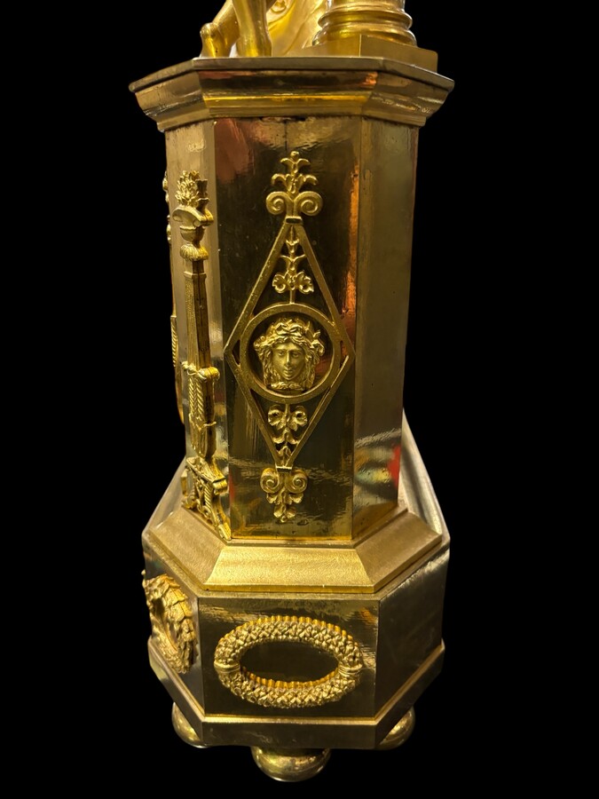 Beautiful Empire period clock in matt and bright gilt bronze depicting a lady playing guitar with an angel. In very good condition, the movement has not been checked. The balance wheel is present. Dimensions: Width: 31.5 cm Height: 43 cm Depth : 13 cm