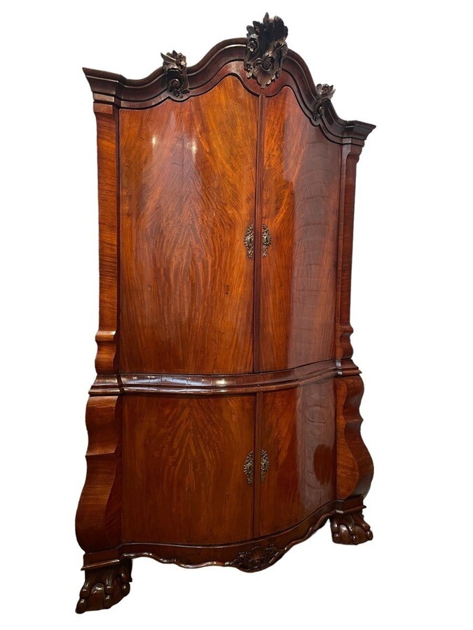 Beautiful large Dutch mahogany corner cupboard from the 18th century. Curved corner cupboard with 4 doors and 4 small drawers inside and standing on large claw feet. The cabinet is in good condition with normal signs of use.