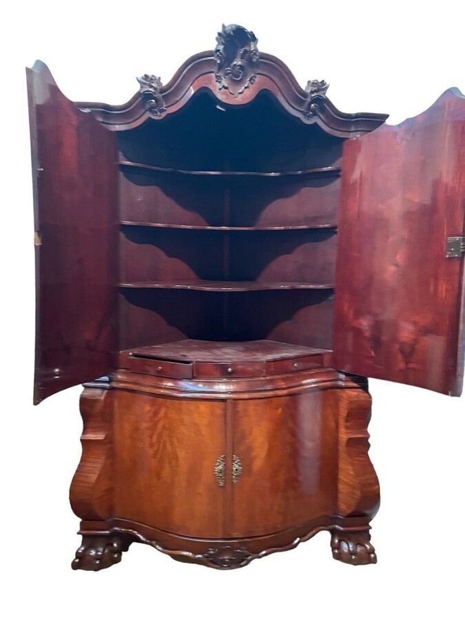 Beautiful large Dutch mahogany corner cupboard from the 18th century. Curved corner cupboard with 4 doors and 4 small drawers inside and standing on large claw feet. The cabinet is in good condition with normal signs of use.